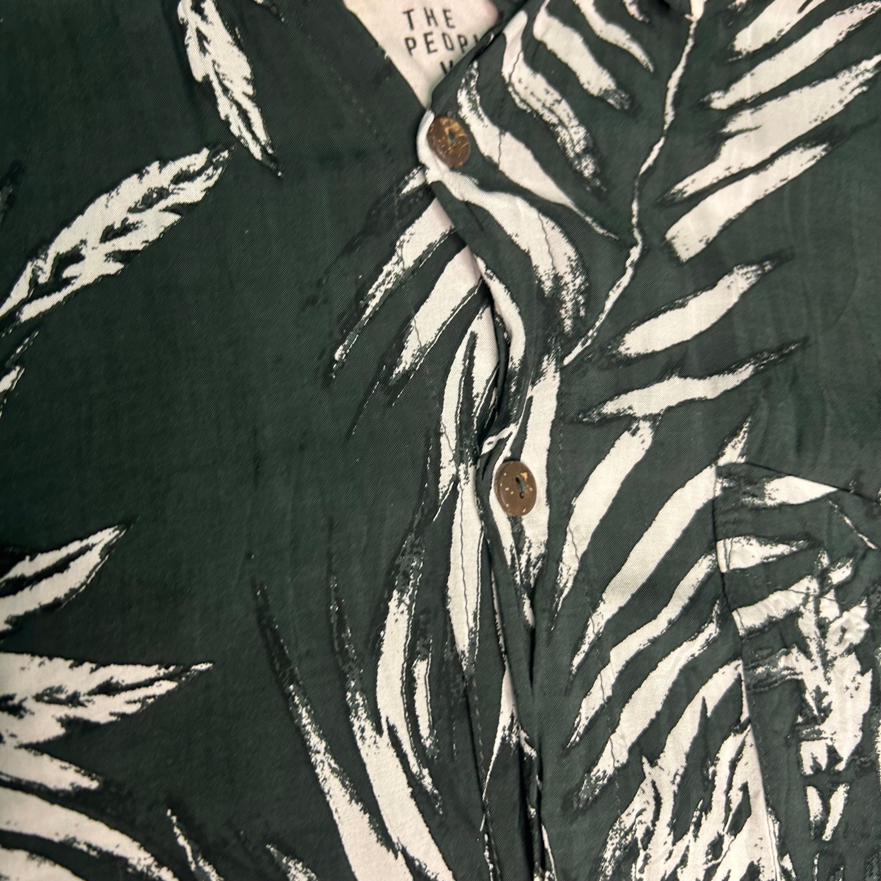 Close-up of a shirt with zebra print and visible brand label.