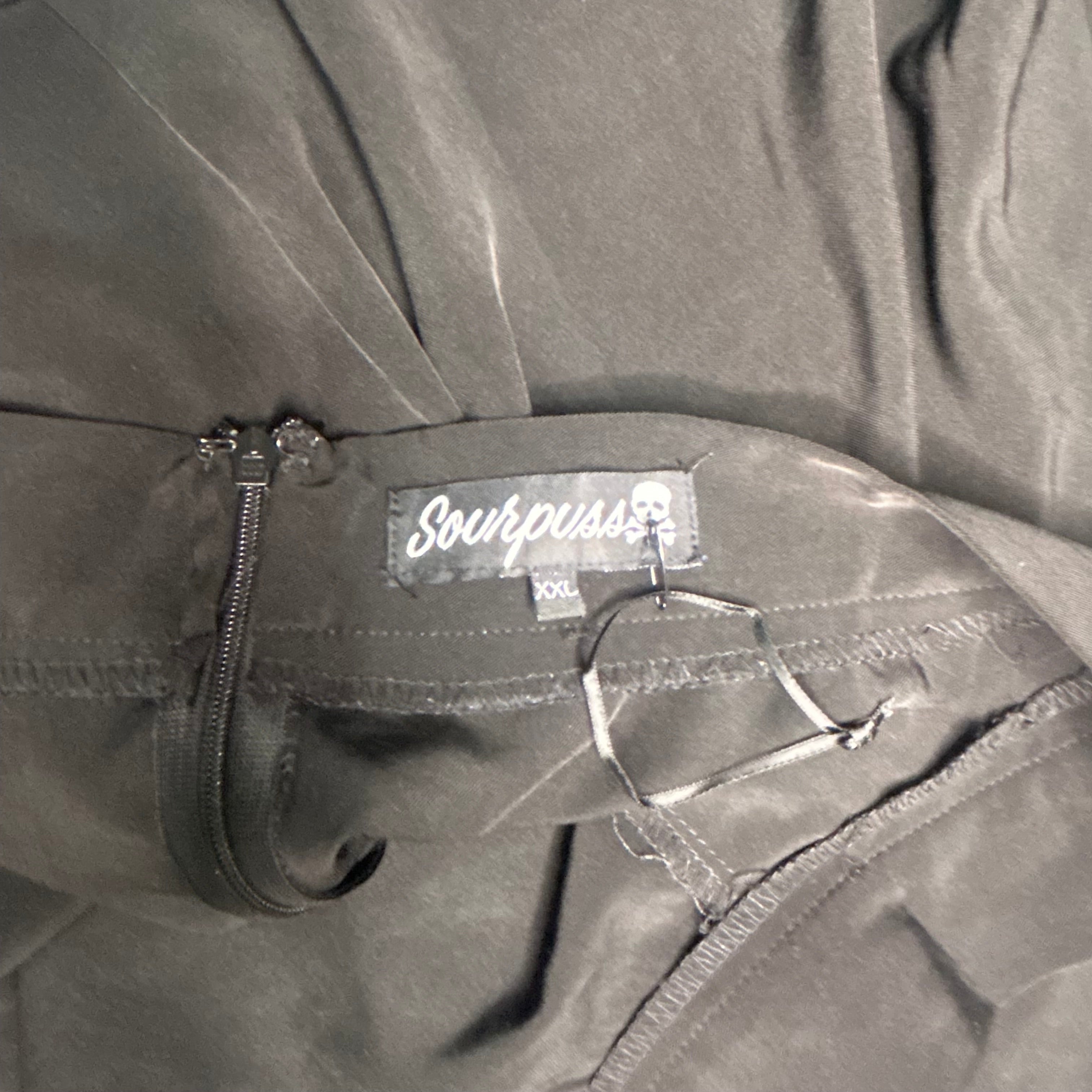 Close-up of a gray jacket with a brand label on a gray background