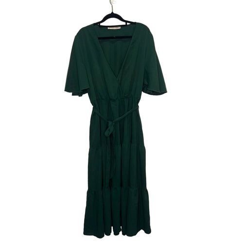 Green dress on a hanger against a plain background