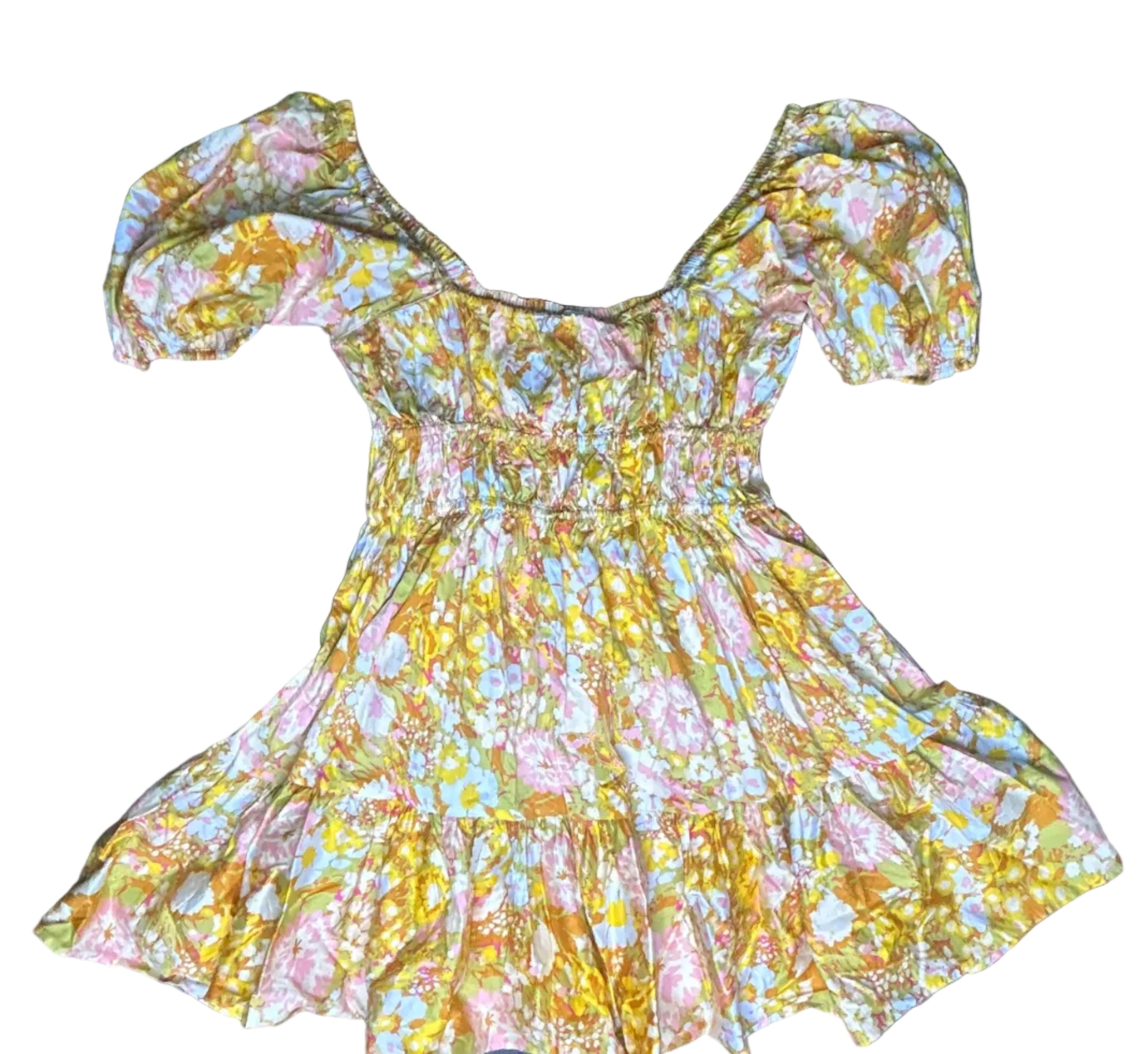 Yellow floral dress on a dark surface with black sticks on either side