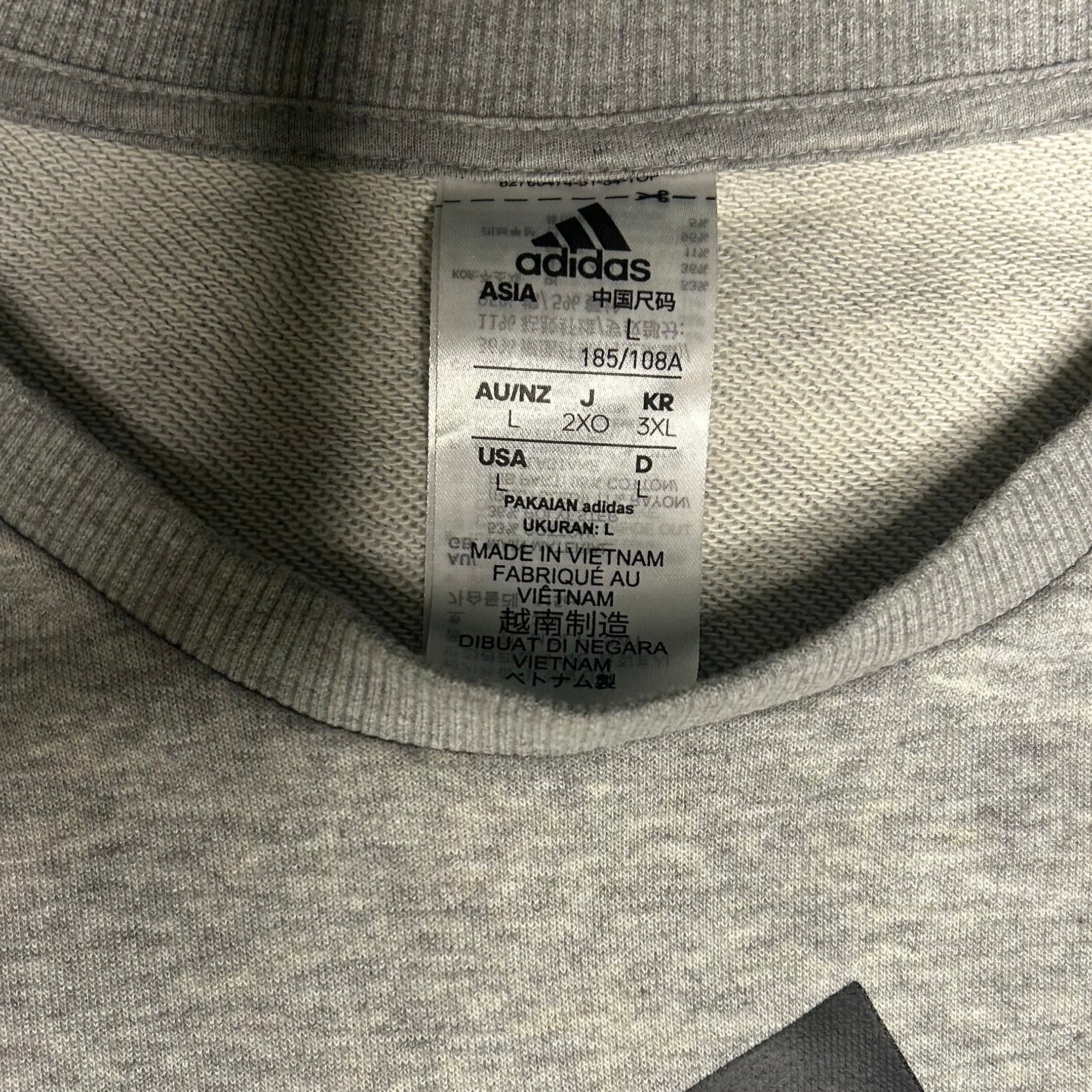 Close-up of Adidas label on a gray fabric background