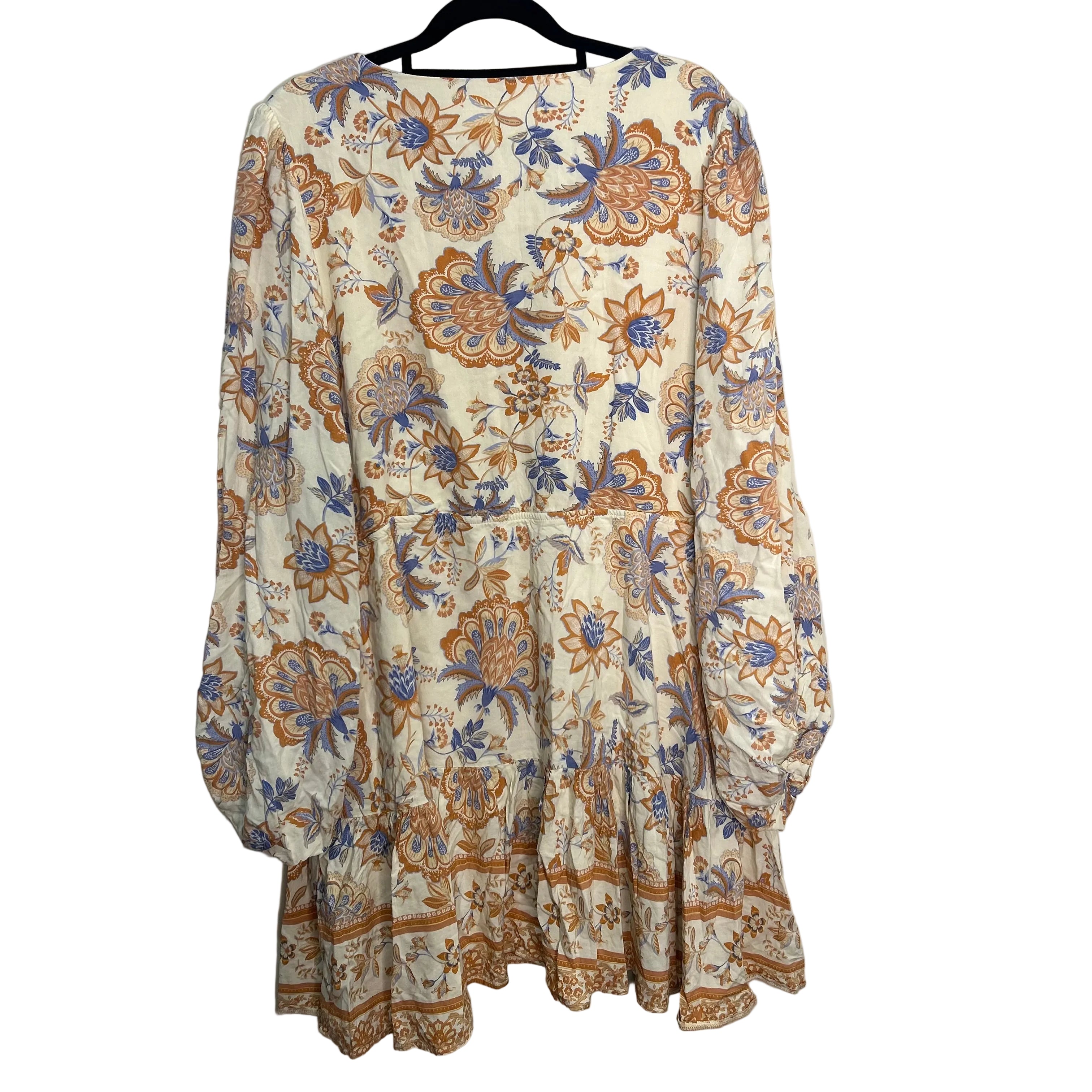Floral patterned dress on a hanger against a plain background