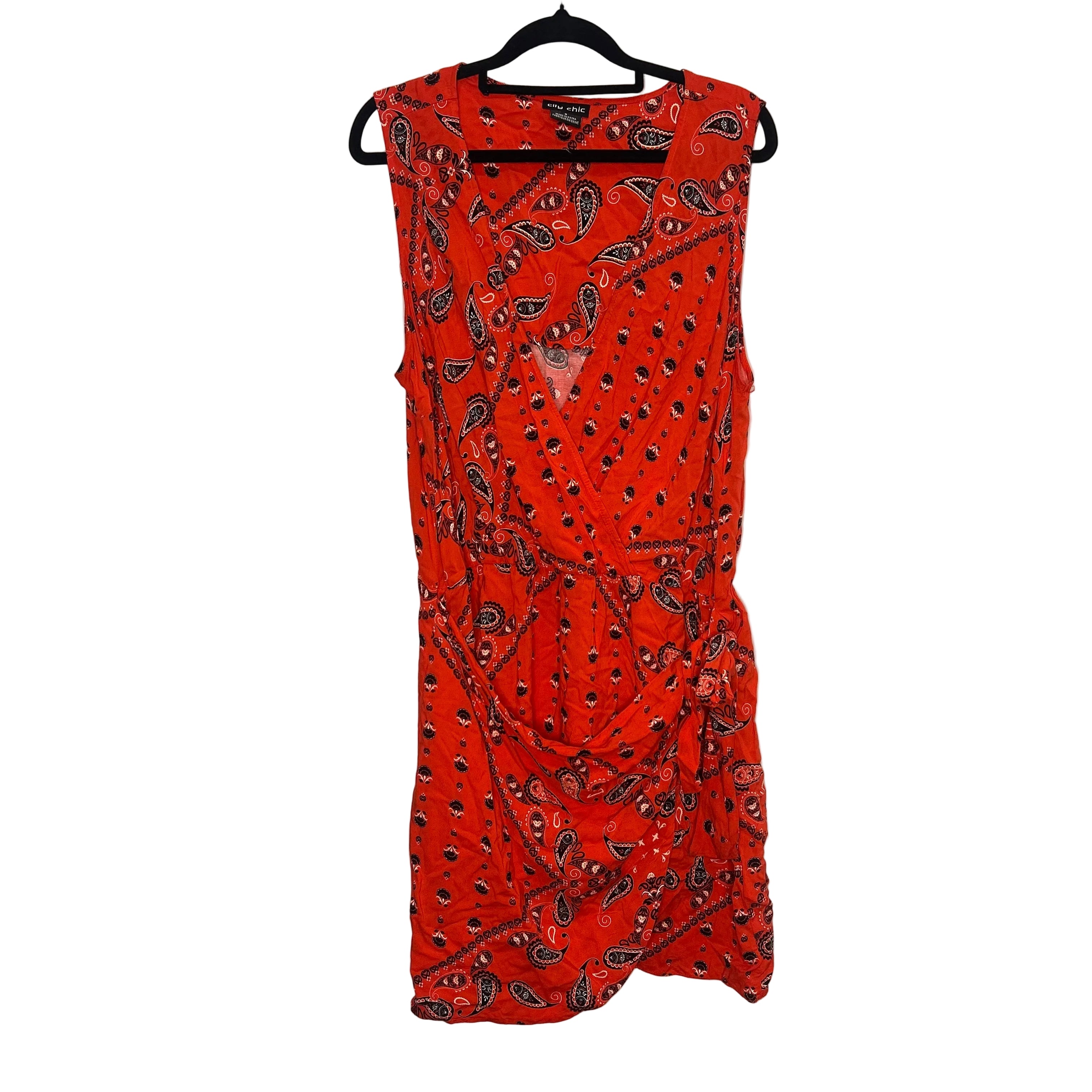 Red dress with black pattern on a hanger against a white background