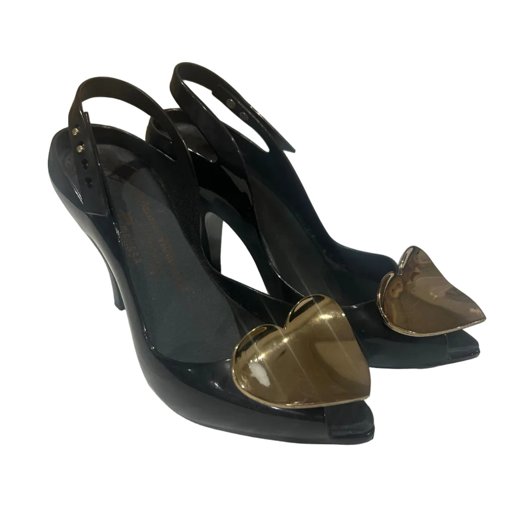 Black high-heeled shoes with gold accents on a white surface