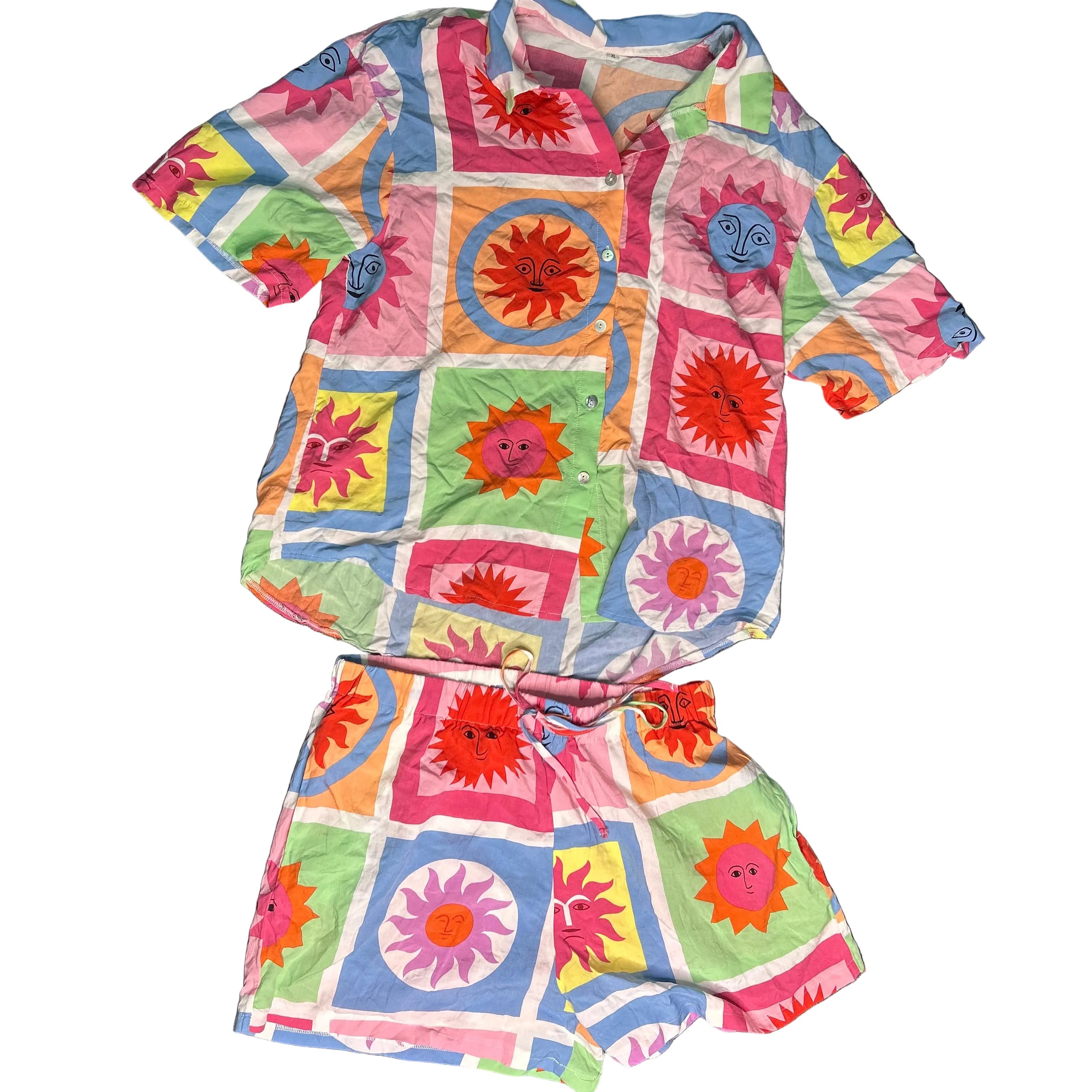 Colorful children's outfit with patterned shirt and shorts on a gray surface