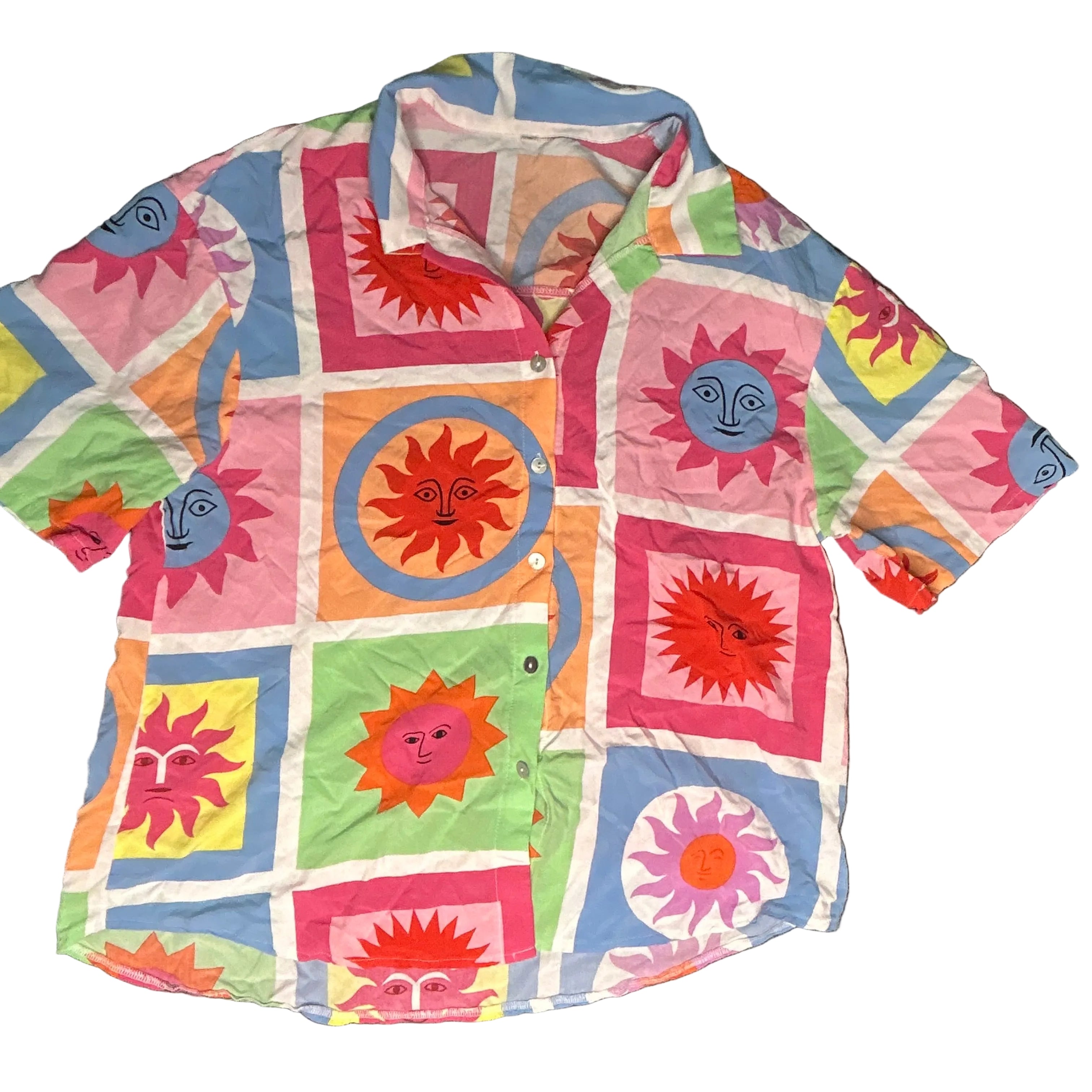 Colorful quilt with geometric patterns and face designs on a dark surface