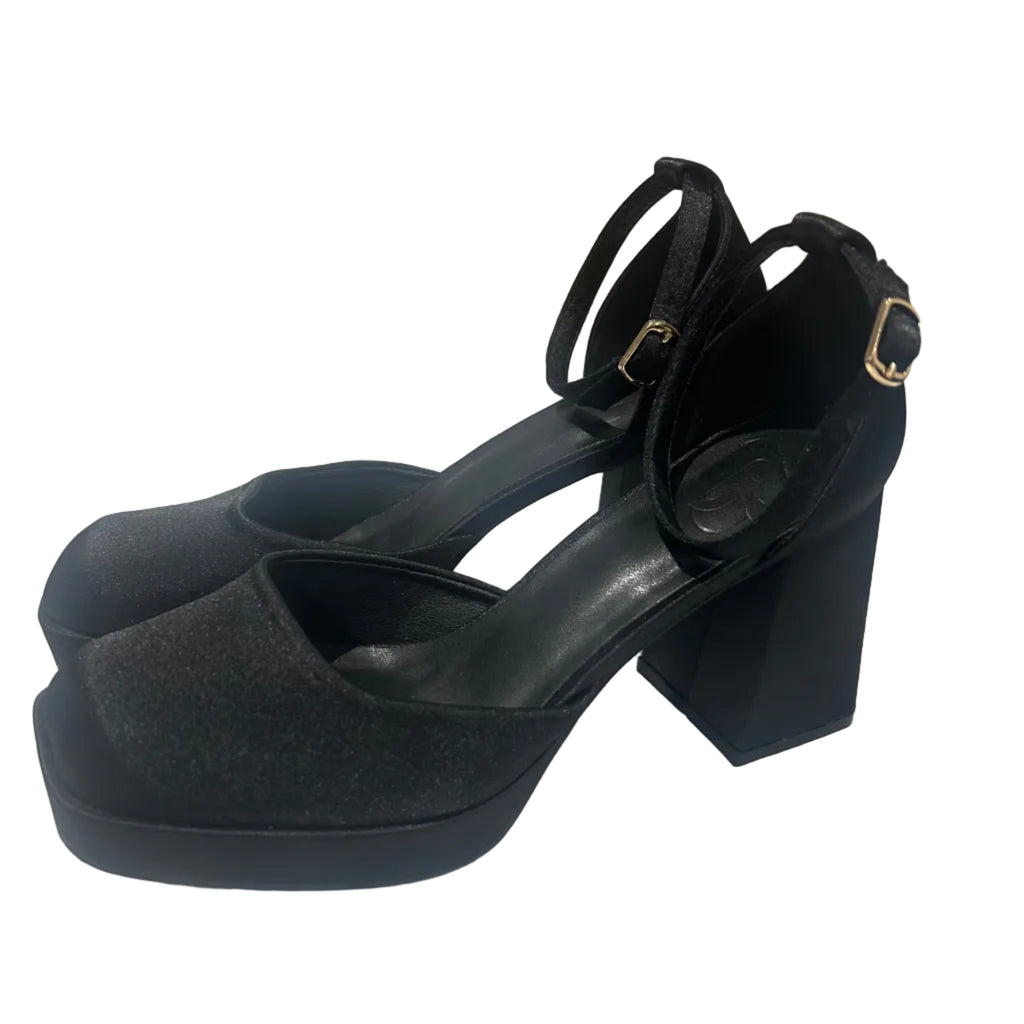 Black high-heeled shoe with a bow on a white surface
