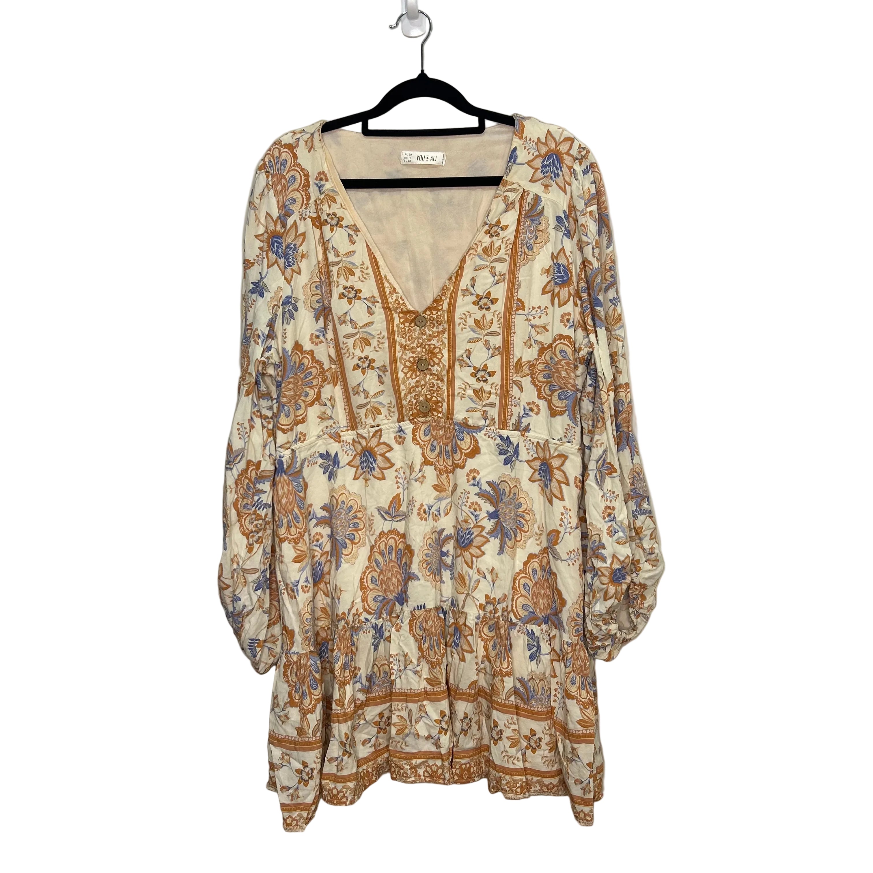 Floral patterned dress on a hanger against a plain background