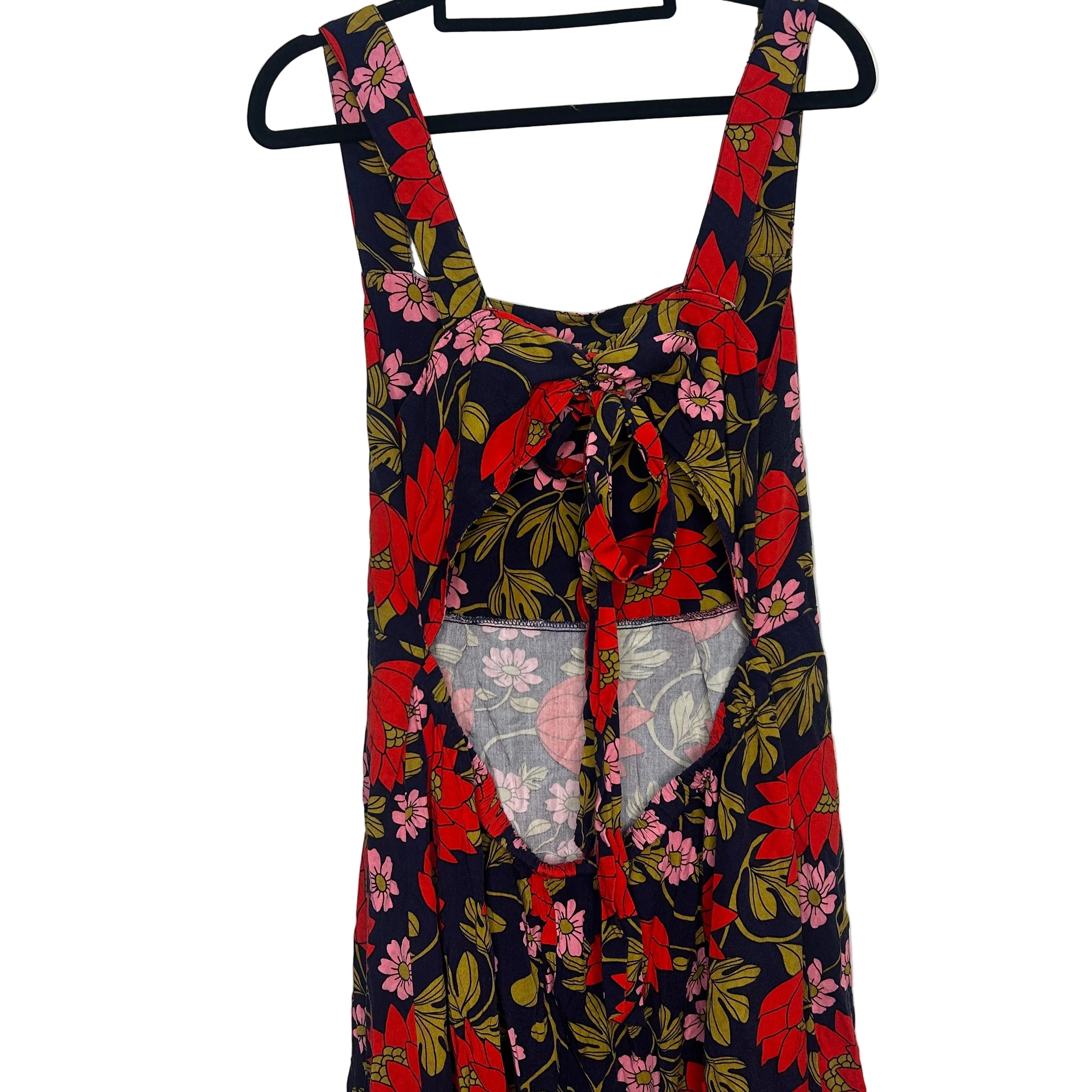 Floral dress with red and pink flowers on a hanger against a white background