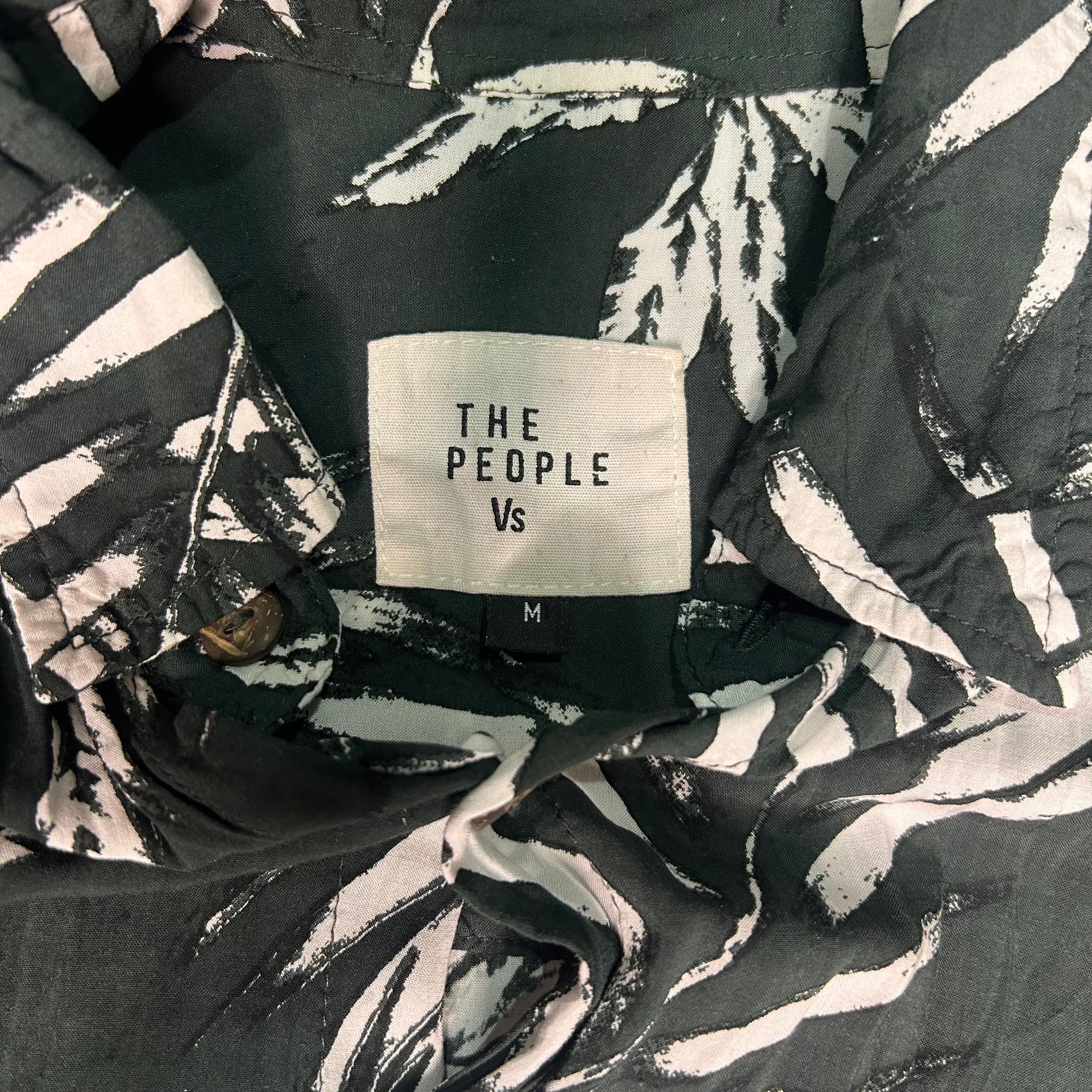 Black jacket with 'The People Vs' label on a patterned background