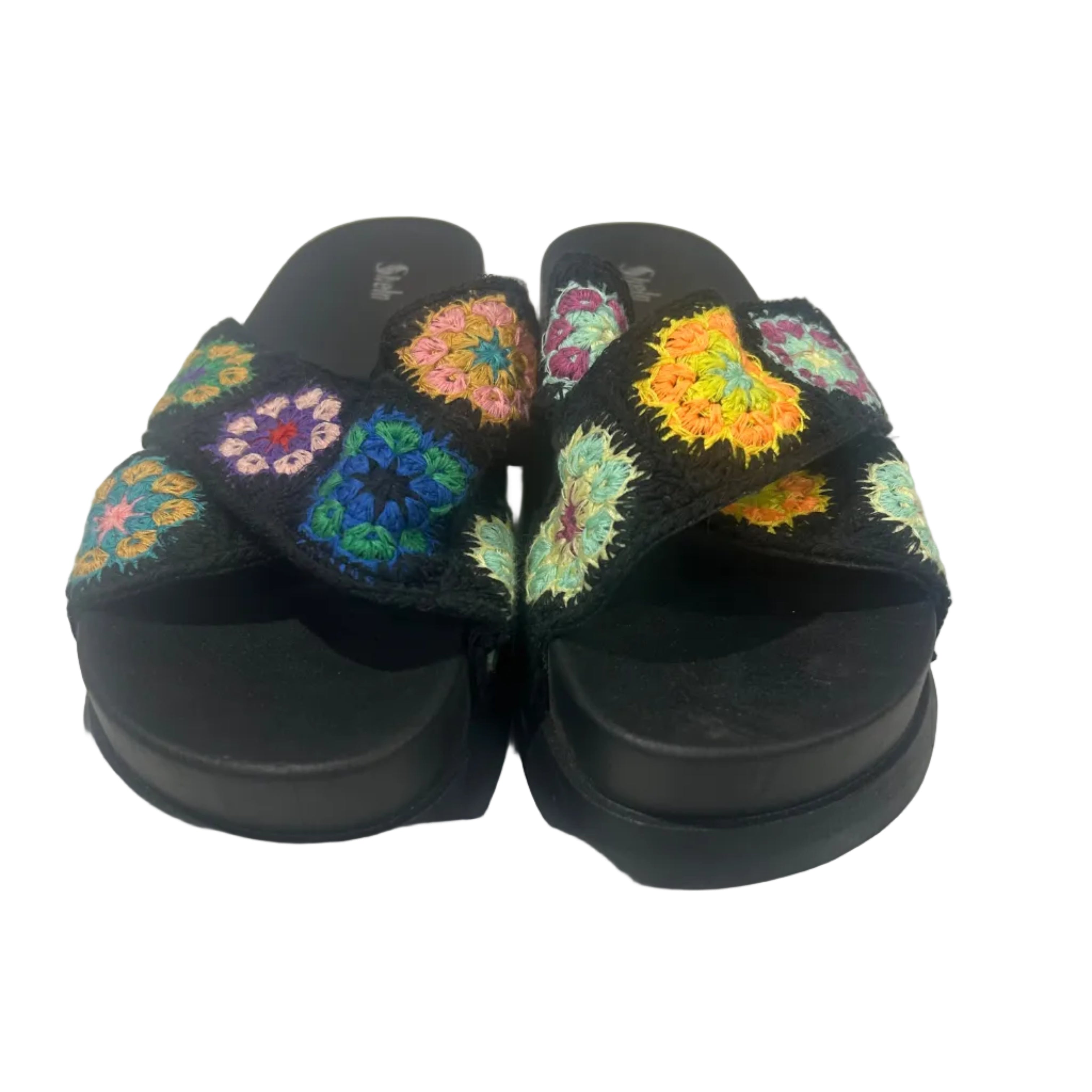 Black slippers with colorful floral patterns on a white surface