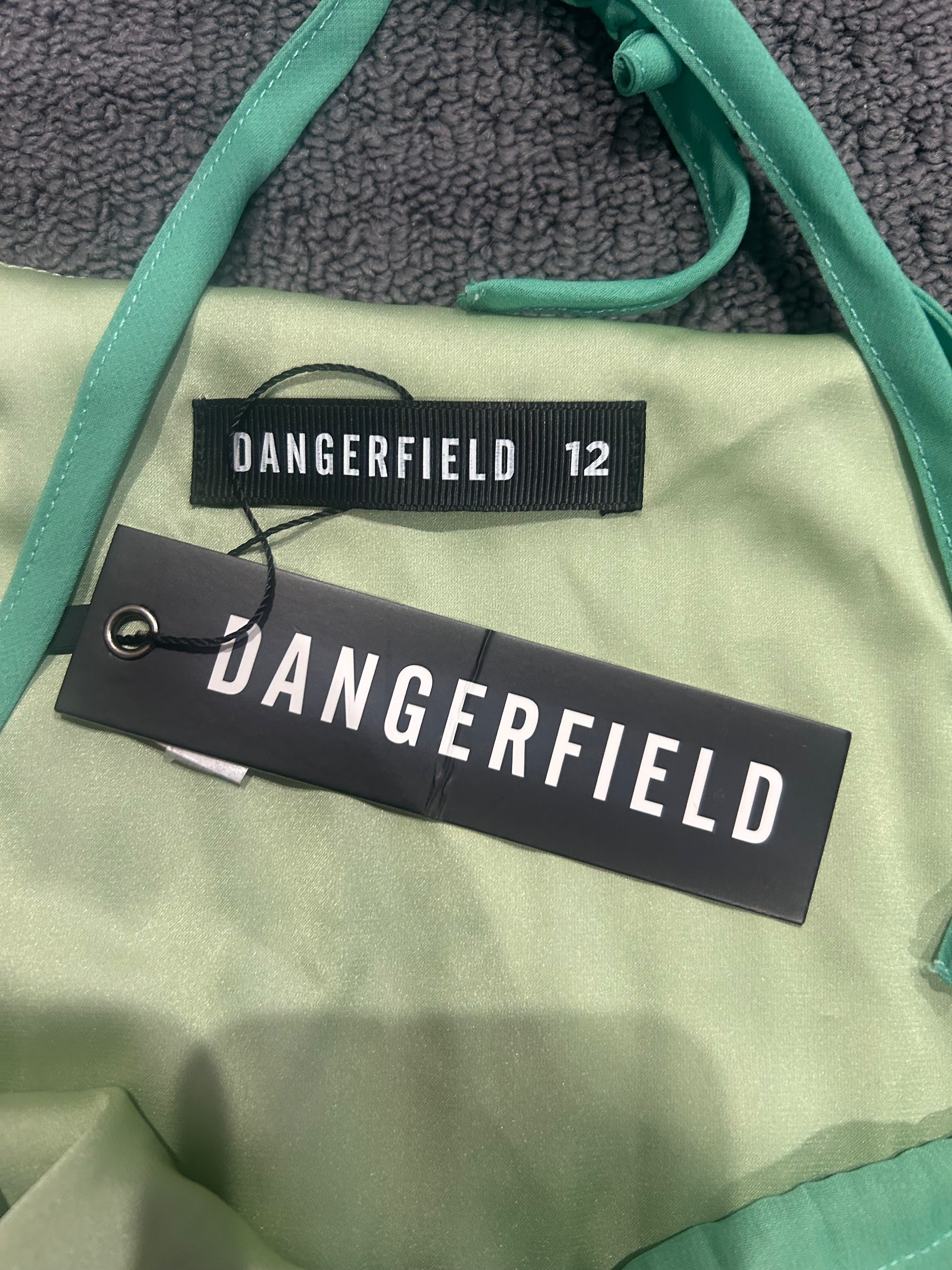 Close-up of a green jacket with 'DANGERFIELD' branding on labels.