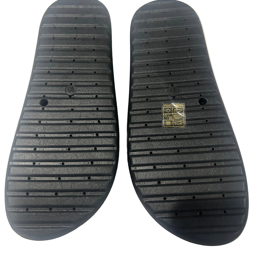 Black shoe soles with a brand logo on a white textured background